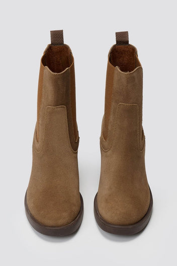 Tan suede Chelsea ankle boots with block heel and elastic side panels, front view on grey backdrop