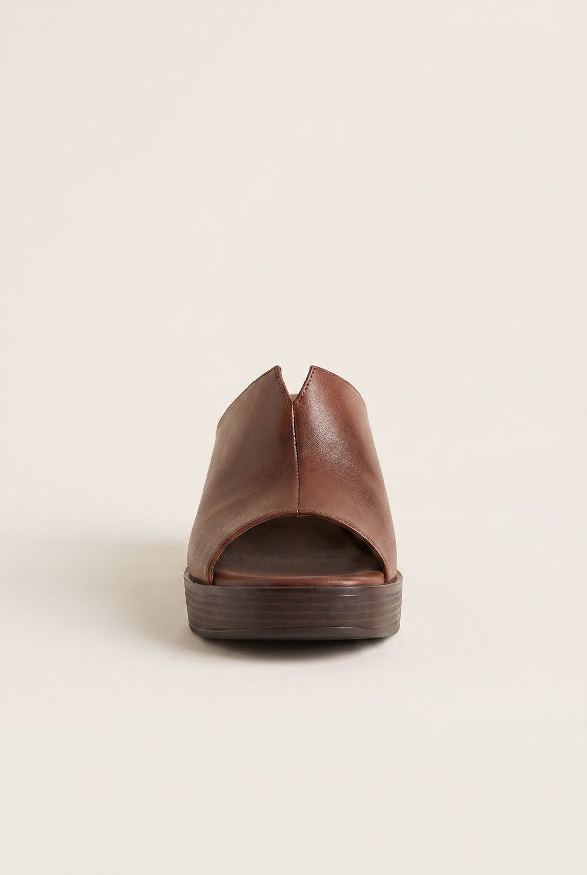 Brown leather block-heel platform mule with open toe, front view on beige backdrop