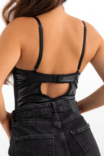 Model wearing black leather corset top with sheer mesh panels and cut-out back, rear view on a light grey backdrop