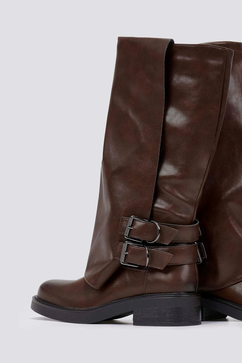 Brown leather knee-high boot with buckle straps and chunky sole, side view on a light grey background
