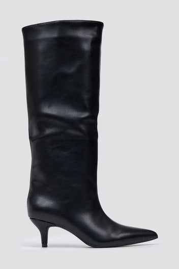 Black leather knee-high pointed toe boot with slouchy shaft and kitten heel, side view on a light grey background