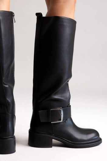 Pair of black leather knee-high biker boots with buckle straps and chunky block heels, front view on a light grey background