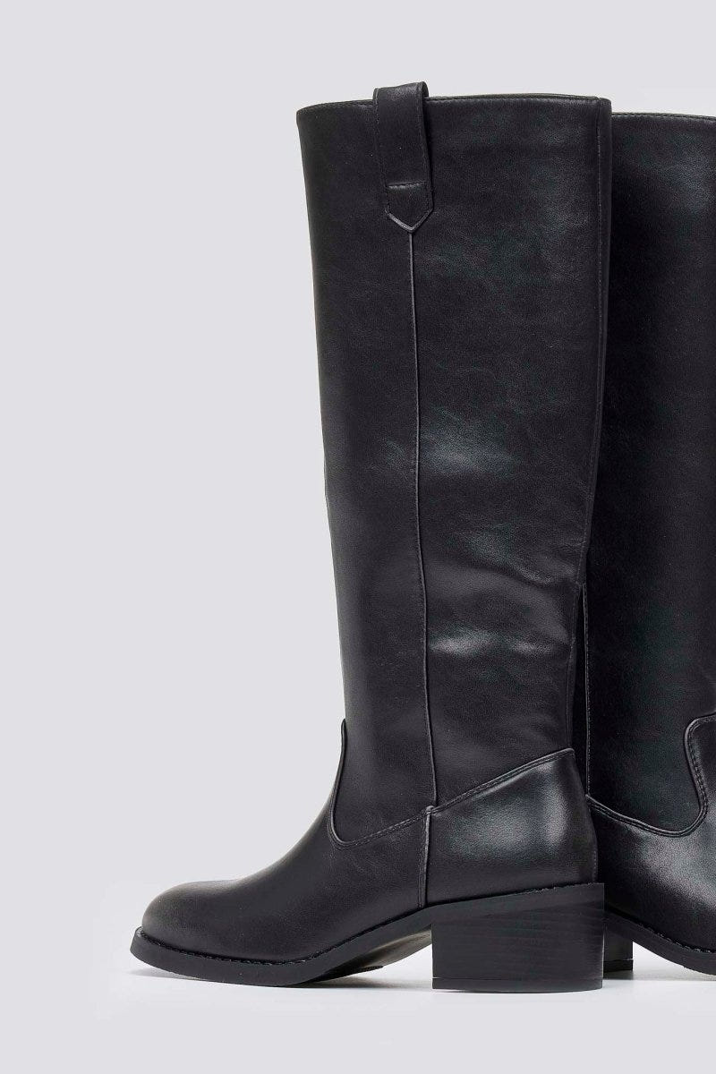 Black leather knee-high boot with round toe, chunky block heel and pull tab at the back, side view on light grey