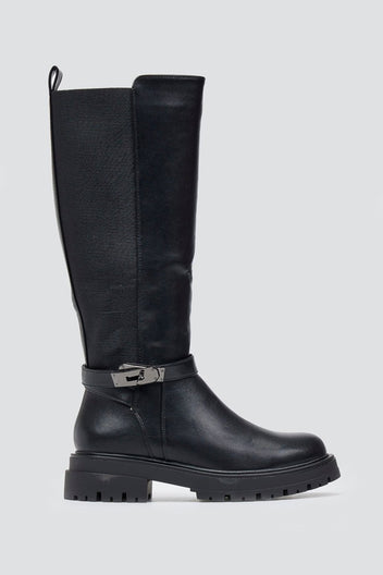 Black knee-high lug sole boot with textured shaft and buckle strap, side view on a light grey background
