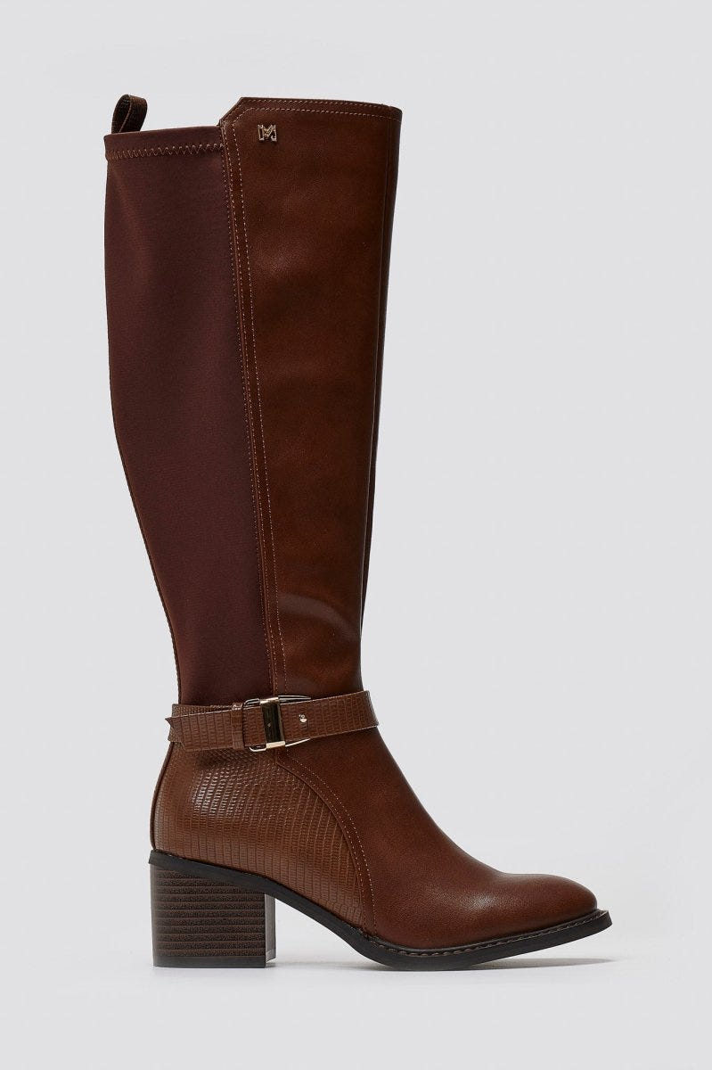 Tan brown leather knee-high block heel boot with gold buckle strap and stretch panel, side view on a light grey background