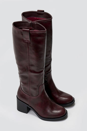 Pair of brown knee-high boots on a light gray background