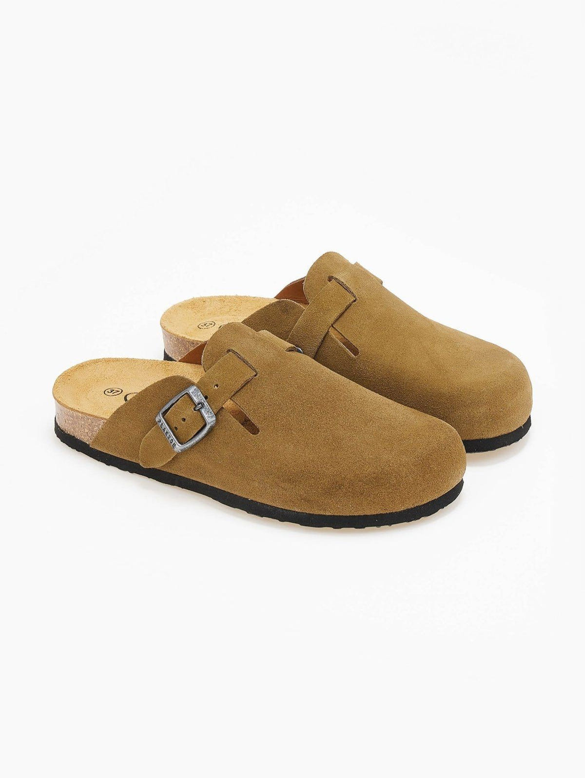 Pair of olive suede clogs side by side on white surface showing buckle straps and inner cork footbed