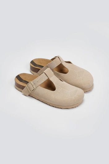 Pair of beige woven T-strap clogs with cork footbeds, angled view on a light background