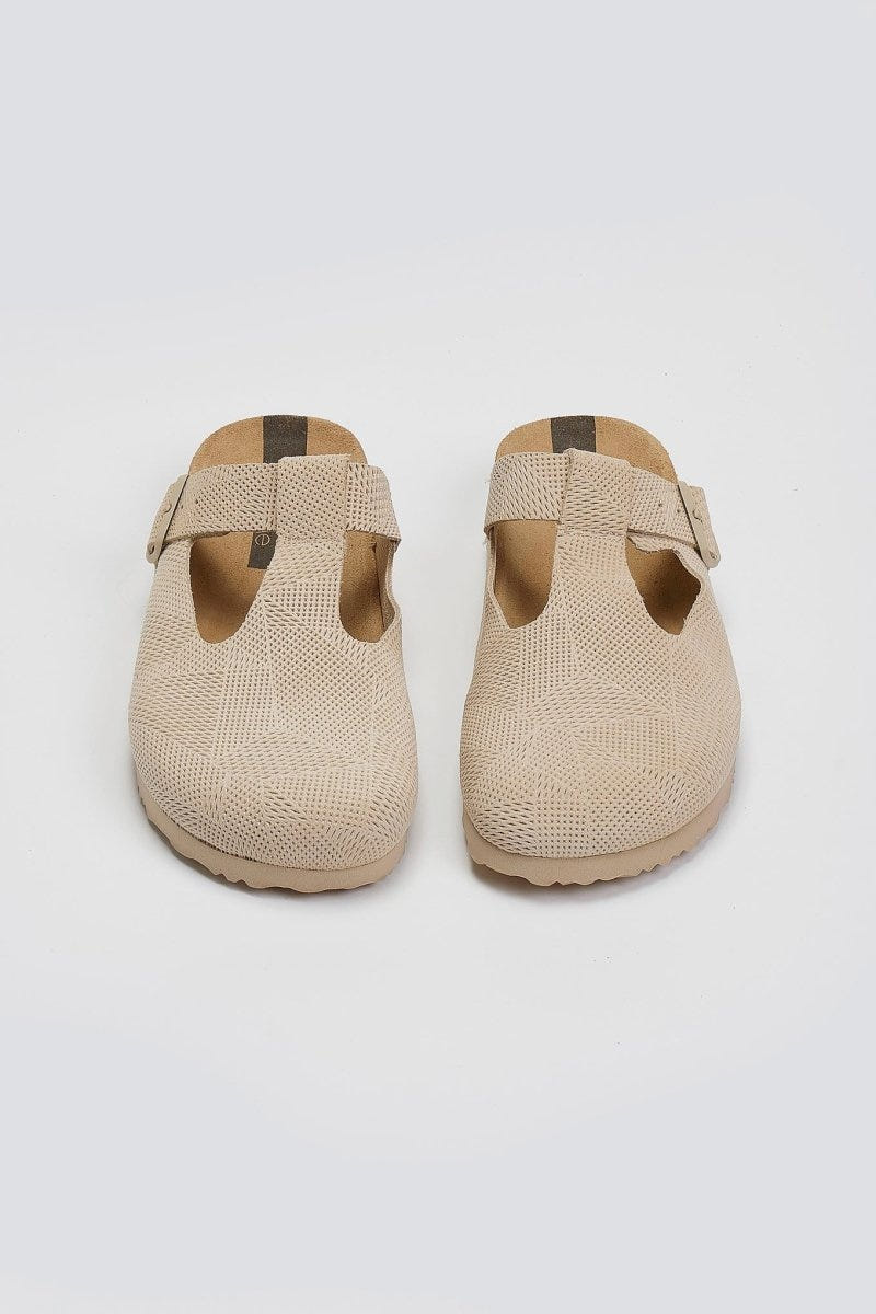 Pair of beige woven T-strap clogs with cork footbeds, overhead view on a light background