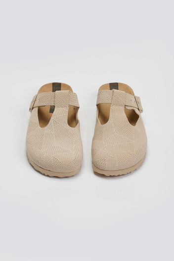 Pair of beige woven T-strap clogs with cork footbeds, overhead view on a light background