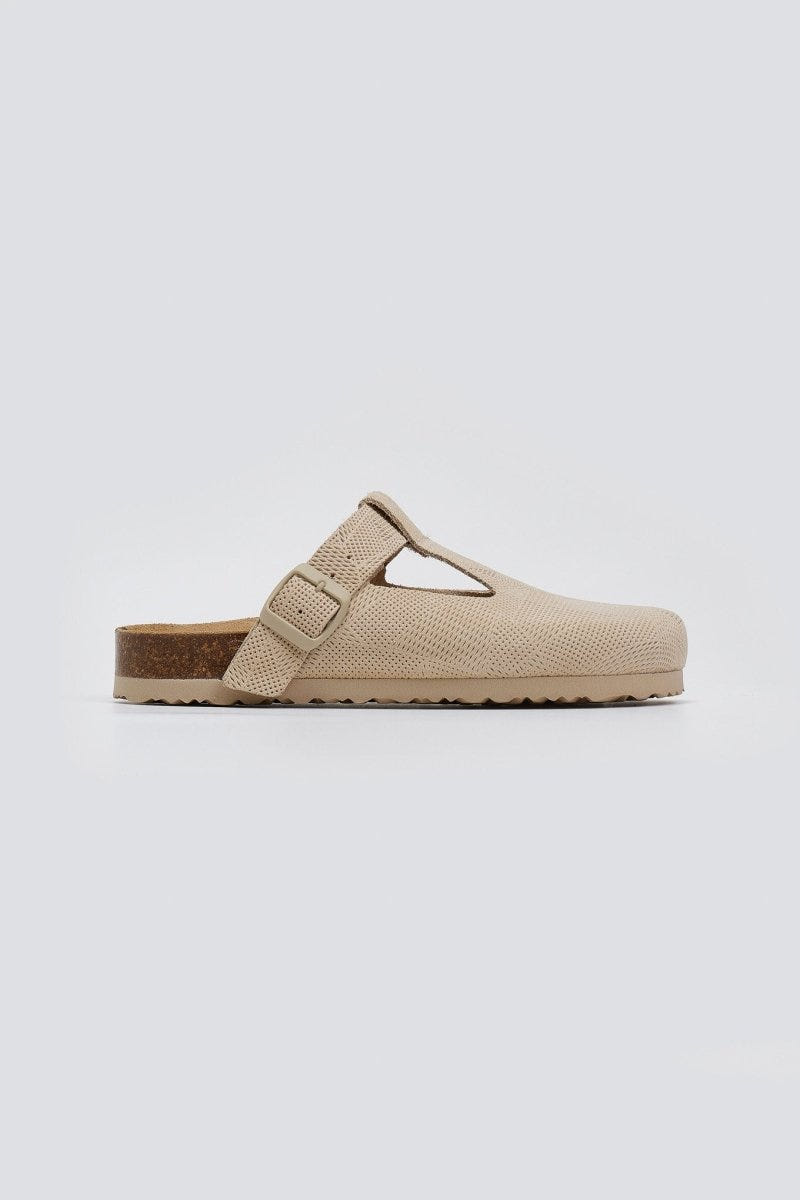 Beige woven clog with T-strap and cork footbed, side view on a light grey background