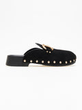 Black suede clog with gold horsebit buckle and gold stud trim on a sole, side view on a white background
