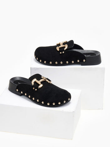 Black suede clog with gold horsebit buckle and gold studs, angled view on a white display block
