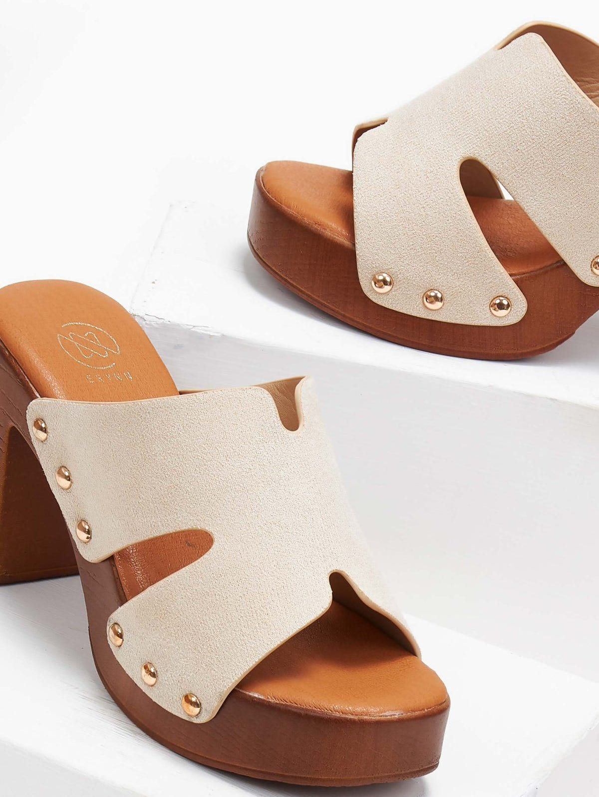 Close-up of cream suede block heel slide with tan wooden-look platform and gold studs, angled view on a white background
