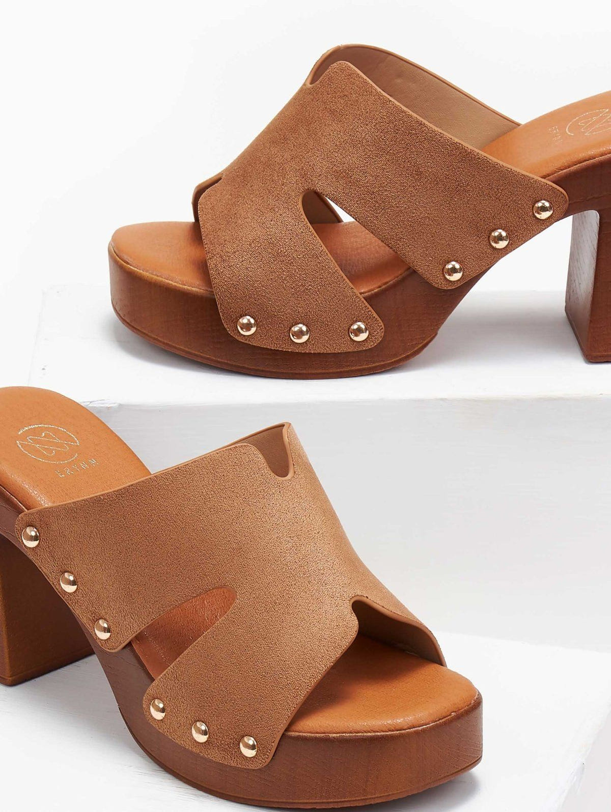Tan suede block heel slide with cut-out straps, gold studs and wooden-look platform, angled close view on a white background
