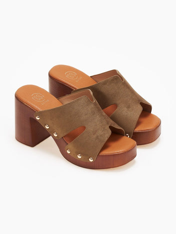 Pair of olive suede block heel slides with cut-out straps, gold studs and wooden-look platform, angled view on a white background