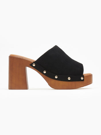 Black suede block heel slide with cut-out straps, gold studs and wooden-look platform, side view on a white background