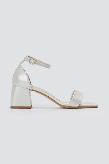 Metallic silver leather block heel sandal with ankle strap and square open toe, side view on a light grey background
