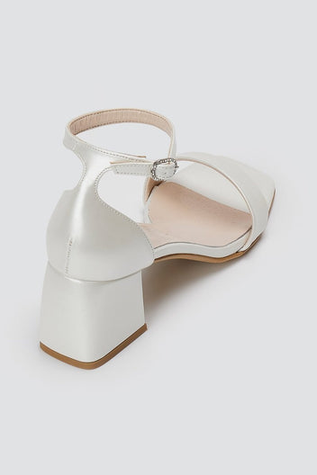 Metallic silver leather block heel sandal with ankle strap and square open toe, rear angled view on a light grey background