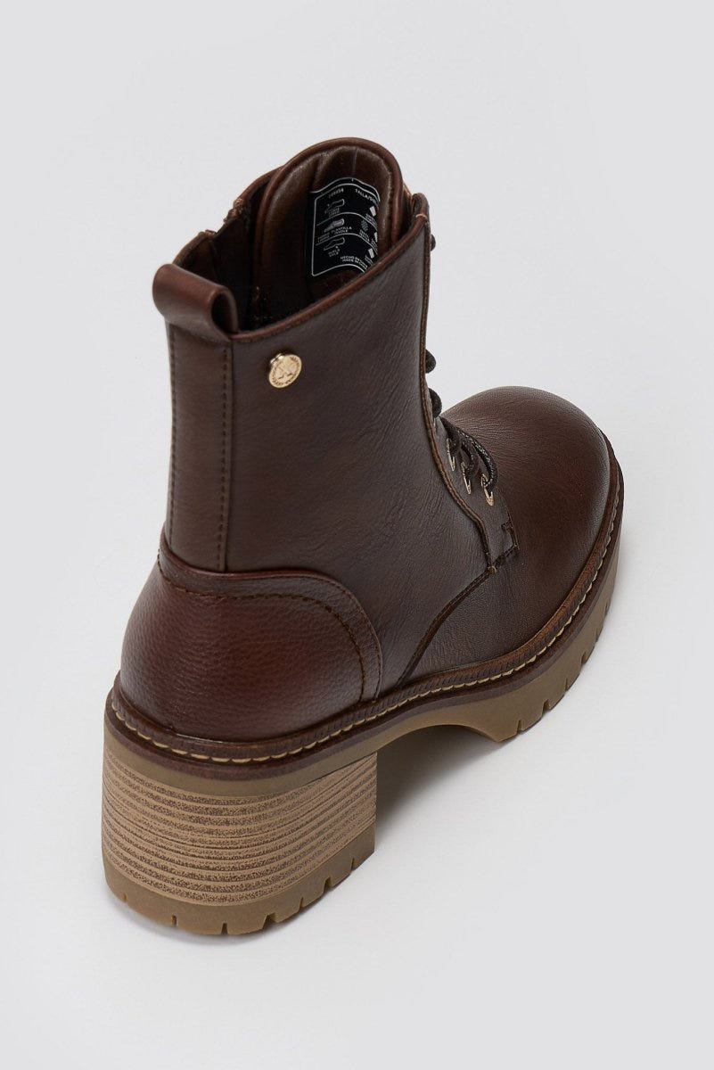Brown leather lace-up ankle boot with chunky block heel and lug sole, angled top view on a light grey background