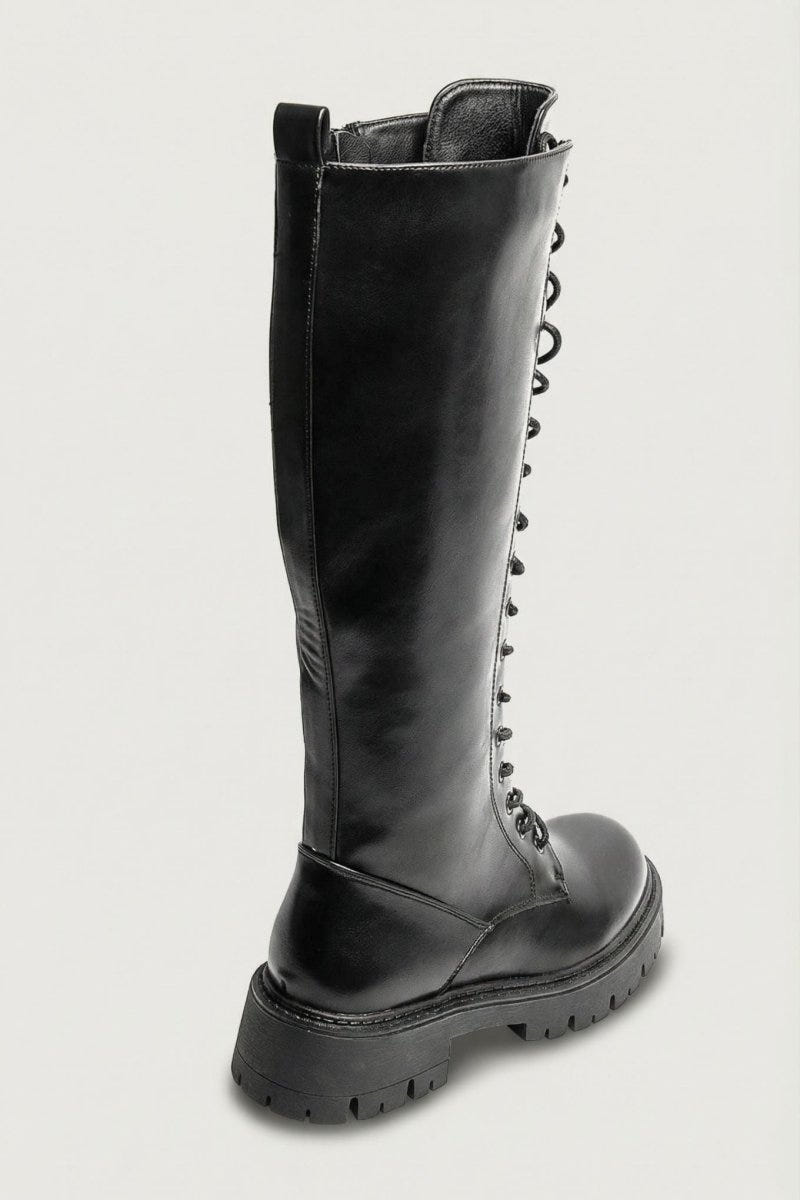 Black leather knee-high lace-up boot with chunky lug sole and side zip, side view on a light grey background