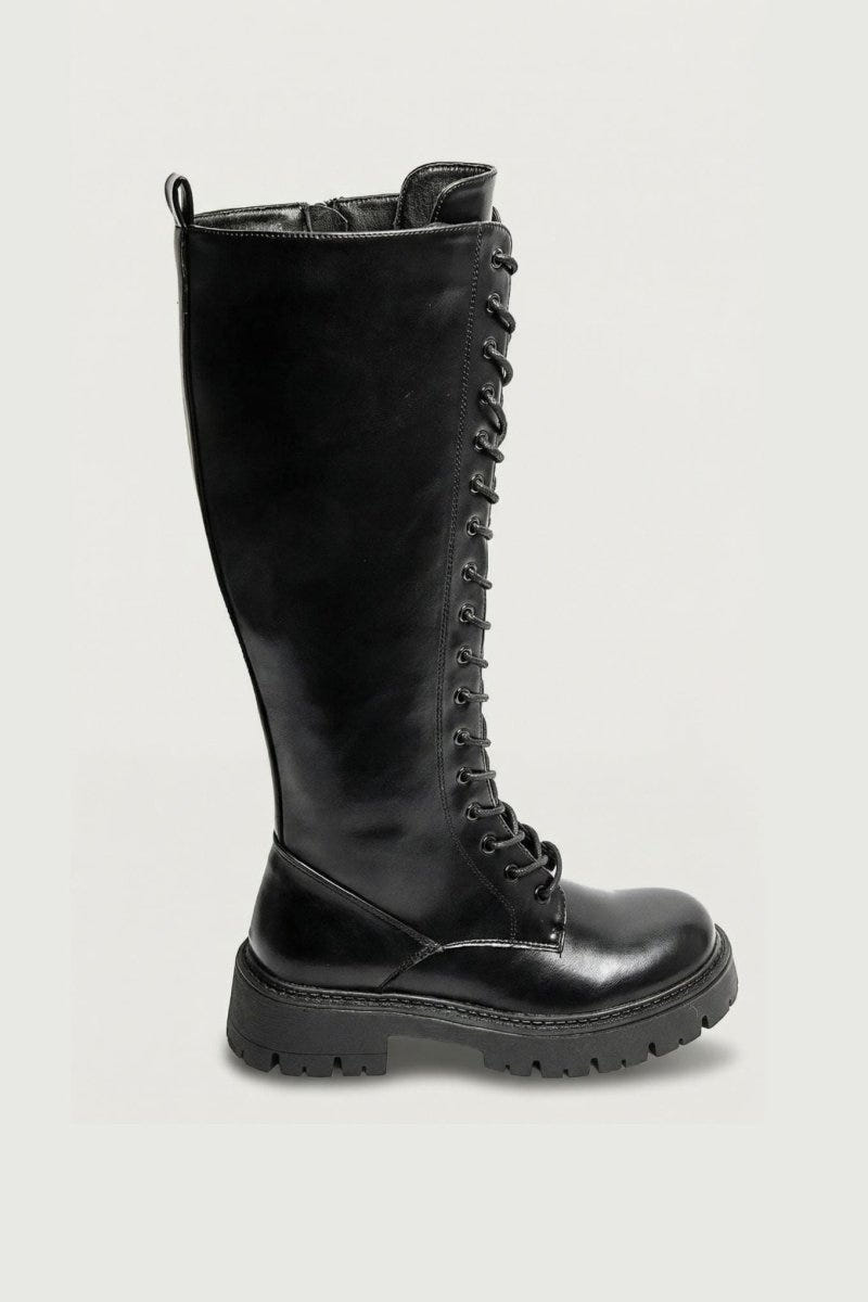 Black leather knee-high lace-up boot with chunky lug sole, angled view on a light grey background