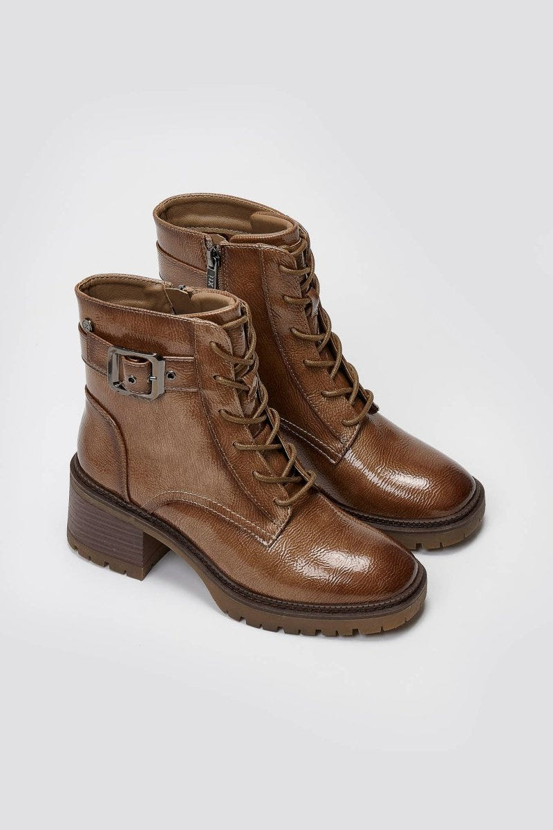 Pair of brown leather lace-up ankle boots with buckle straps and block heels, angled view on a light grey background