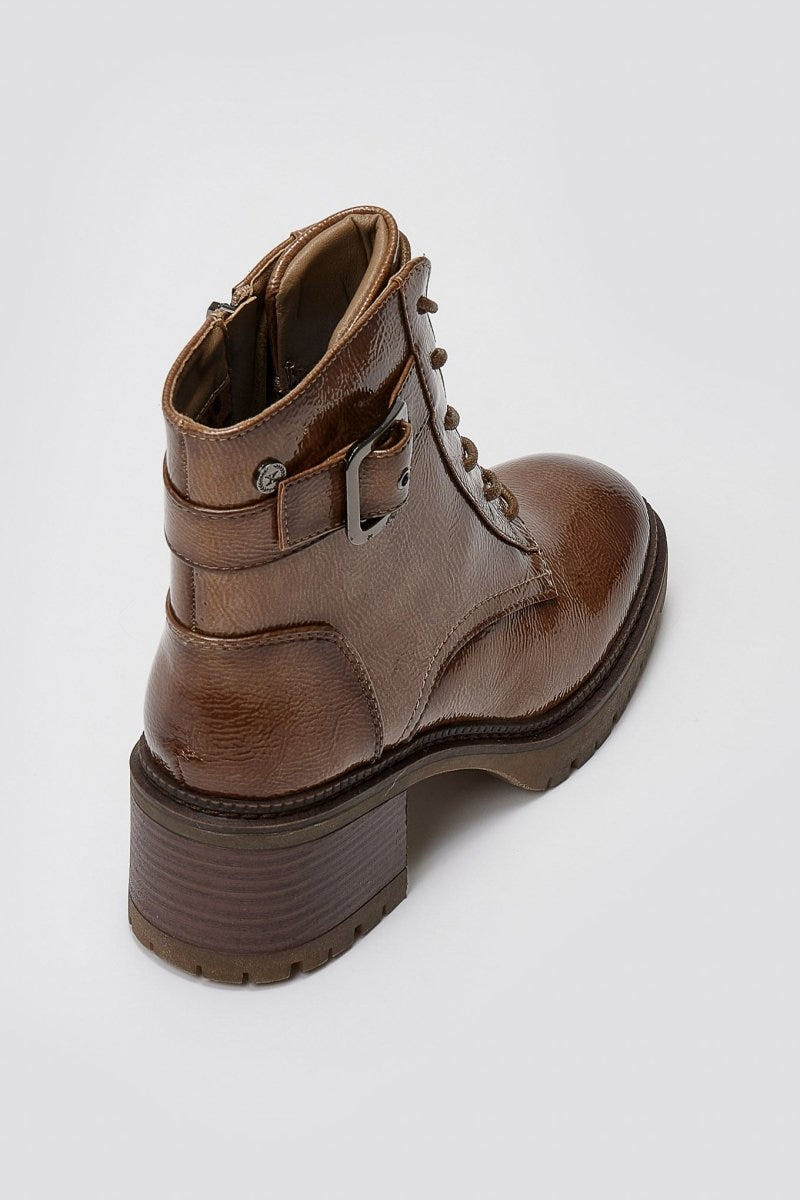 Brown leather lace-up ankle boot with buckle strap and chunky sole, angled top view on a light grey background