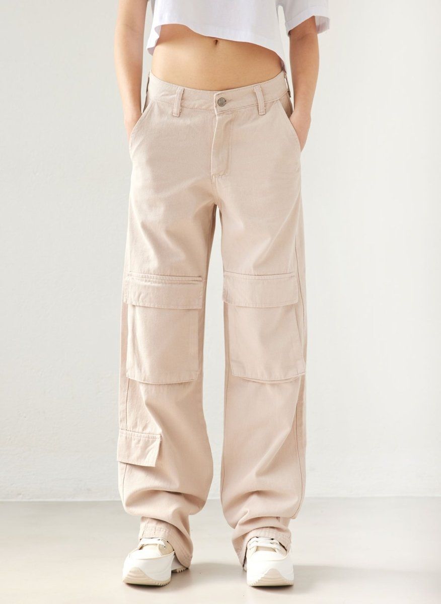 Beige wide leg cargo denim pants with large flap pockets above the knees and side flap pockets, worn on model, front view