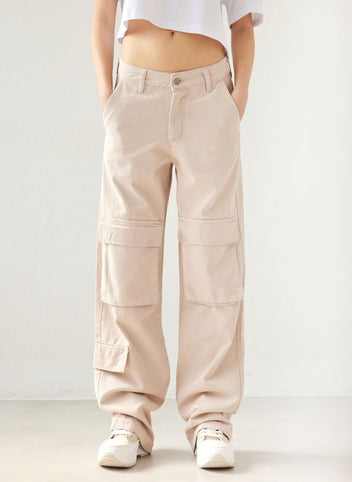 Beige wide leg cargo denim pants with large flap pockets above the knees and side flap pockets, worn on model, front view