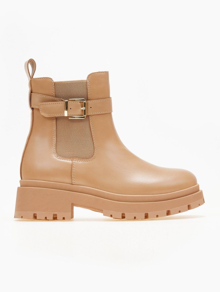 Taupe beige faux leather Chelsea boots with elastic panel, gold buckle strap, pull tab and chunky lug platform sole, side view