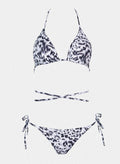 Navy and white leopard print triangle bikini top with halter tie and matching side-tie bikini bottom, laid flat on white