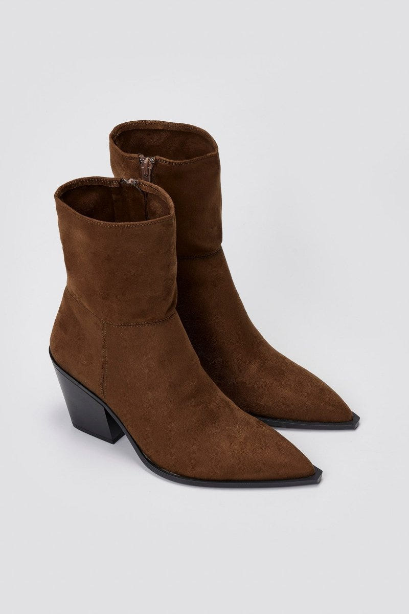 Pair of dark brown suede pointed ankle boots with block heels, angled view on a light grey background