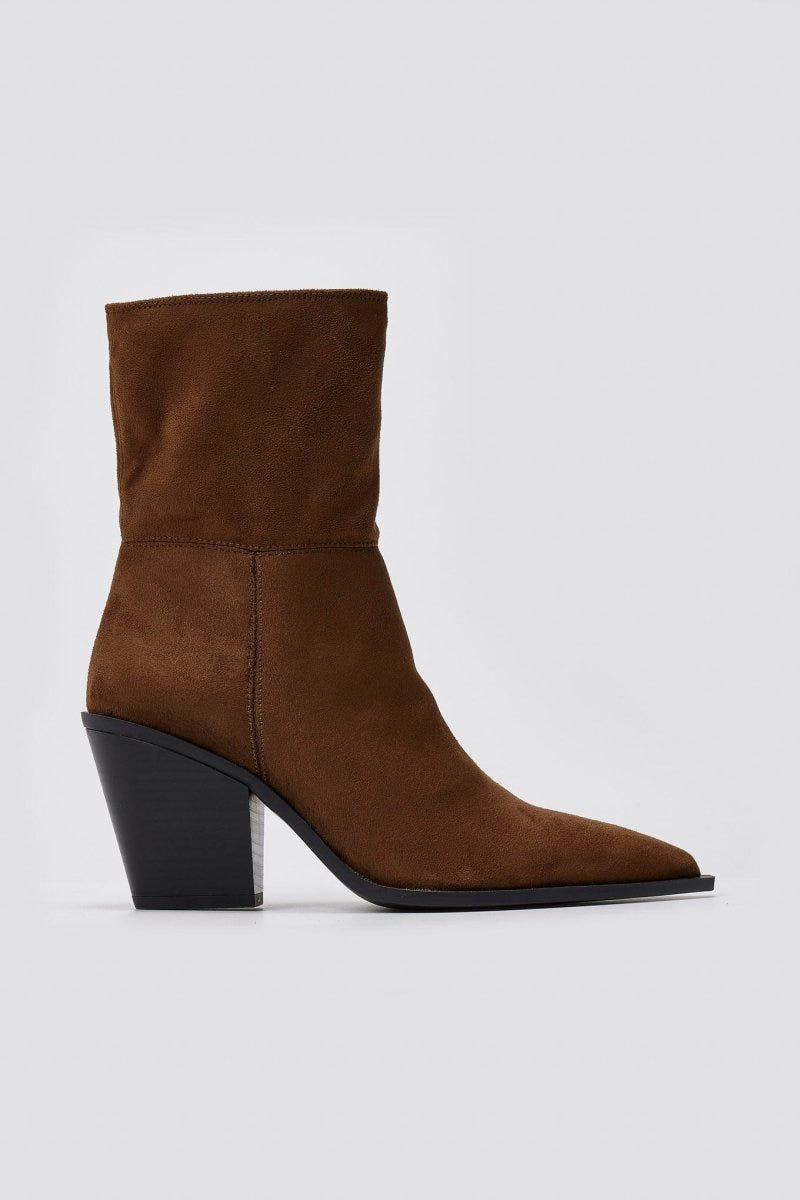 Dark brown suede pointed ankle boot with block heel and smooth shaft, side view on a light grey background