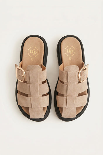 Overhead view of beige suede fisherman slides with caged straps, large gold buckles and chunky black soles