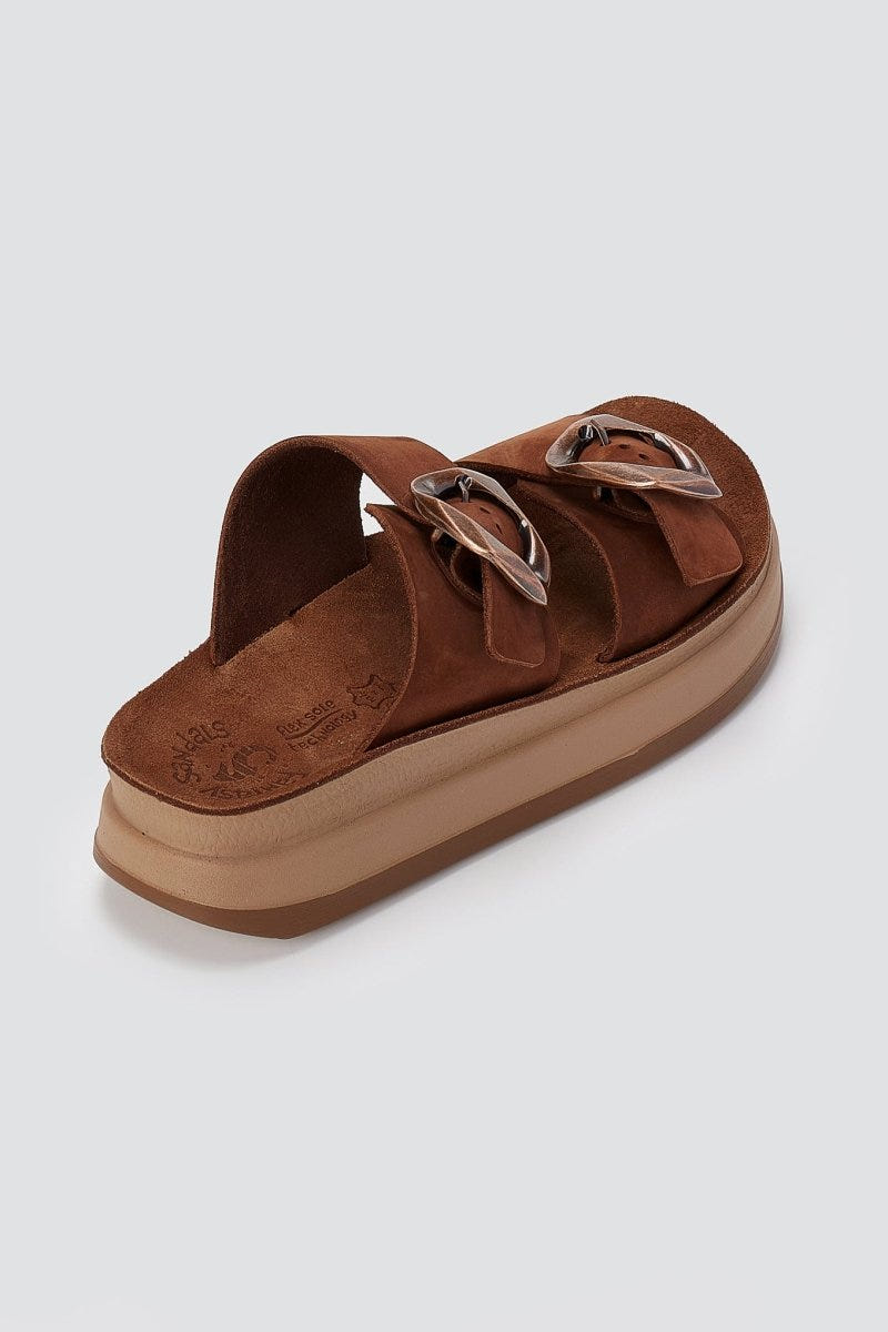 Single brown suede slide flatform with wide strap and round silver buckles, three-quarter side view of thick tan platform sole