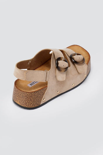 Taupe suede platform sandal with two straps and gold ring buckles on tan footbed, three-quarter side view on light grey