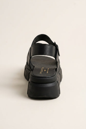 Back view of black leather chunky flatform sandal with ankle strap and thick ridged sole