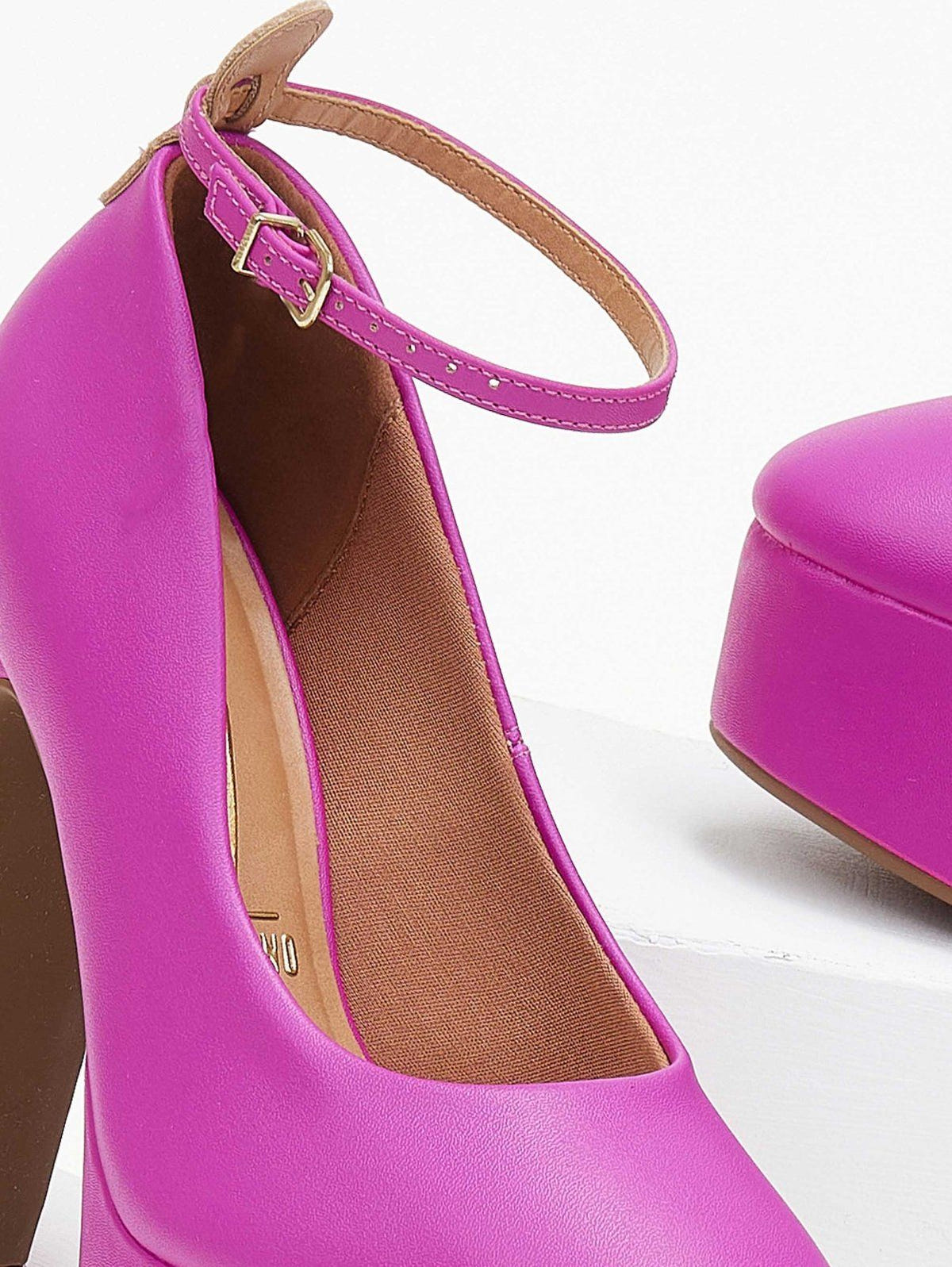 Close-up of fuchsia platform pump with gold buckle on ankle strap, tan insole and rounded toe.