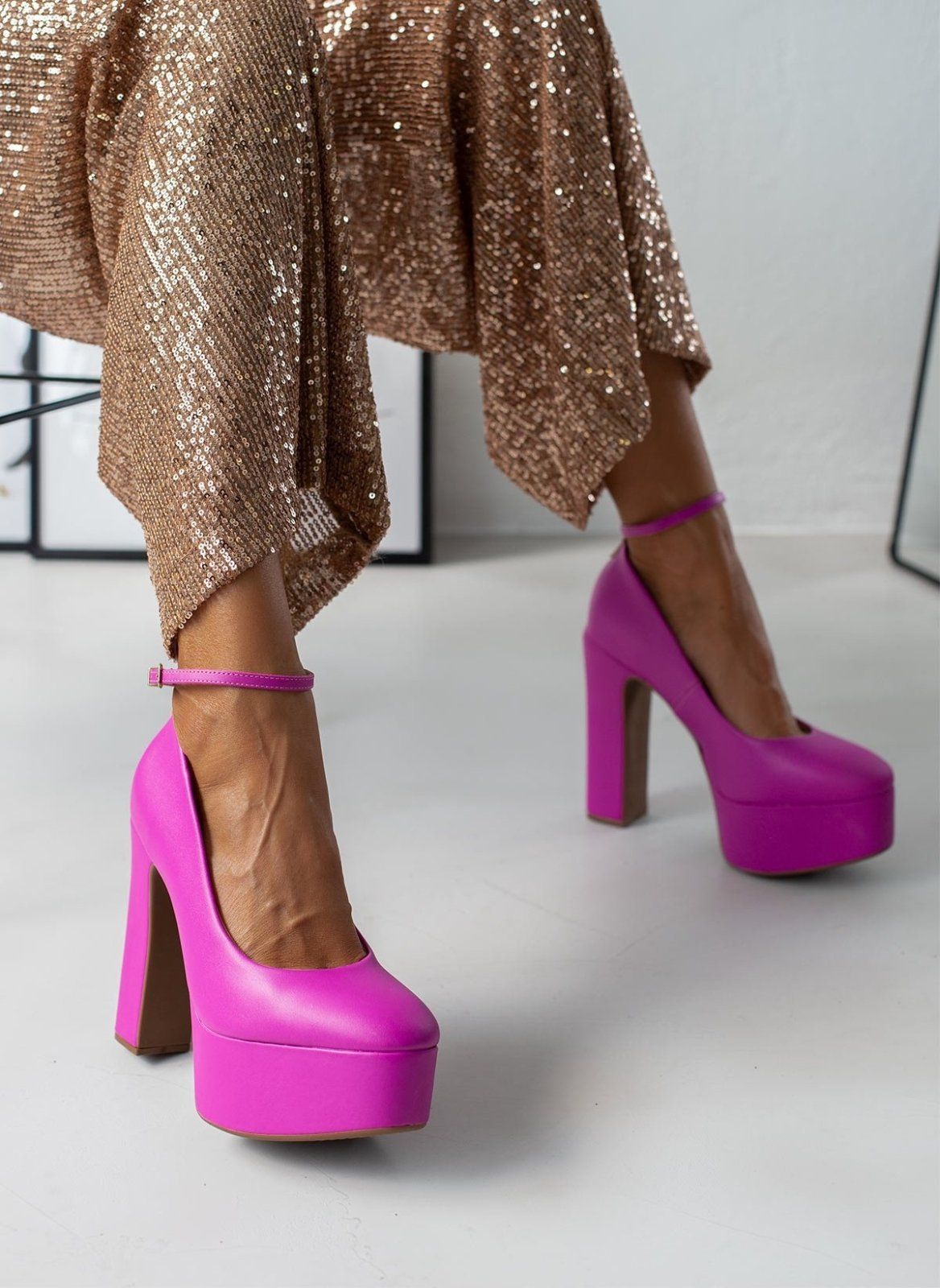 Fuchsia platform pumps with block heels and slim ankle straps, worn on model, full length from the front.