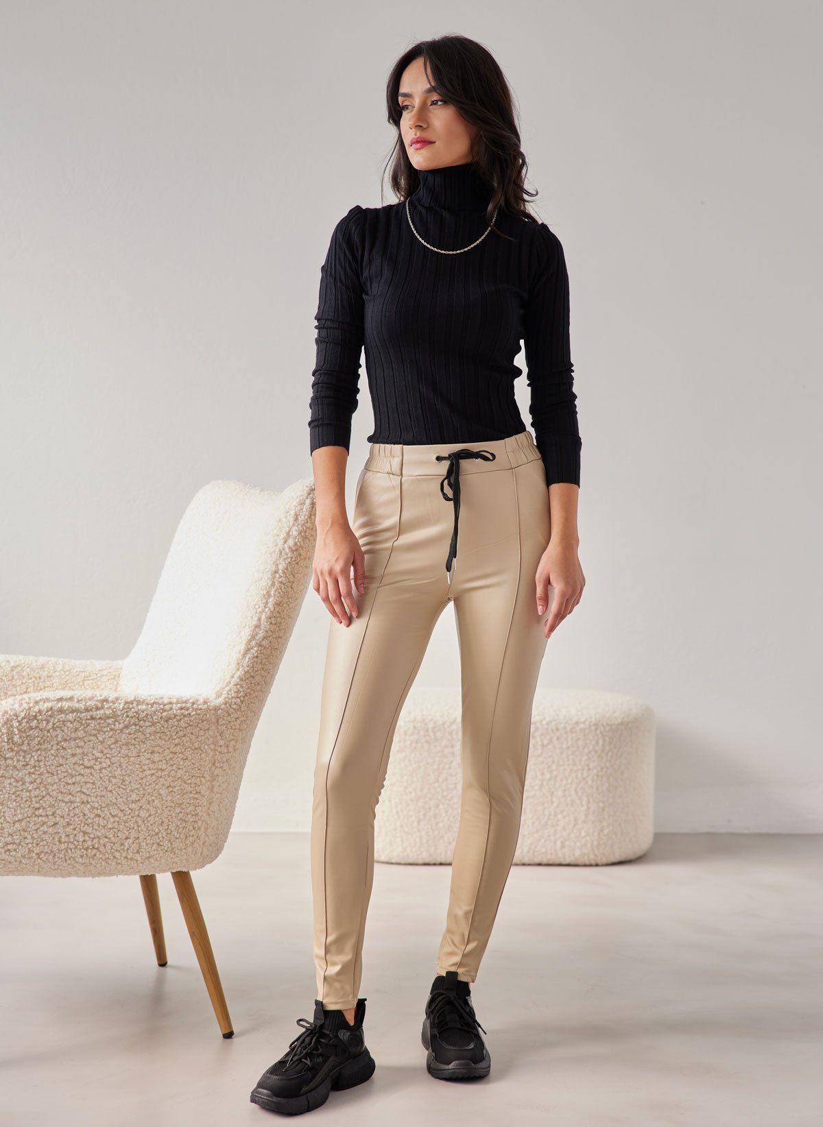 Beige faux leather leggings with vertical seam and drawstring waist, full-length front view on model.