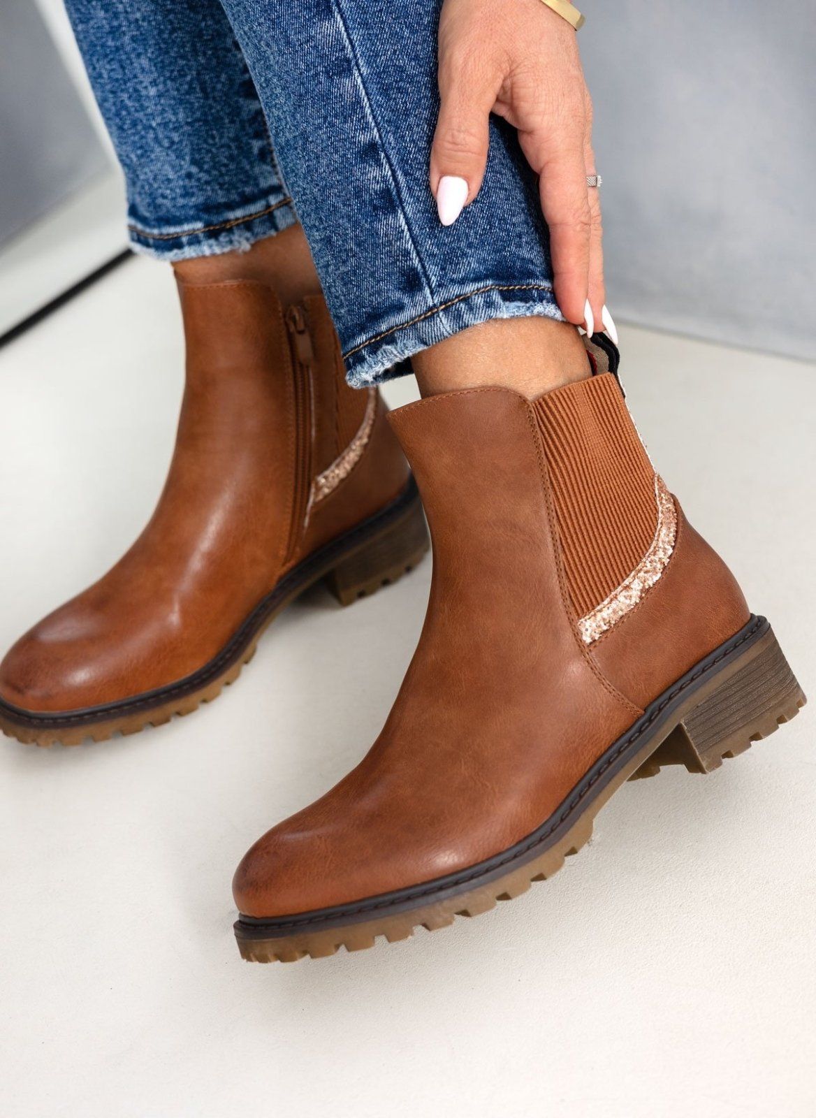 Camel Chelsea ankle boots with glitter-trimmed elastic panel and side zip, worn on model, angled view