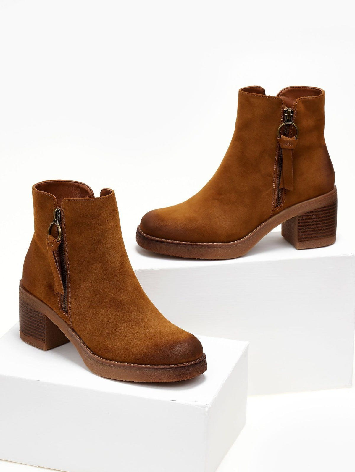 Camel suede ankle boots with side zip, ring pull tassel and block heel, displayed on white blocks
