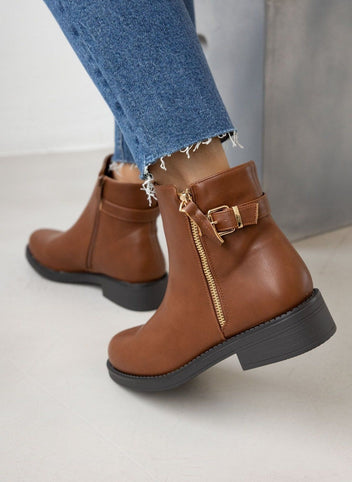Tan ankle boots with gold side zip and buckle strap detail, worn on model, back view