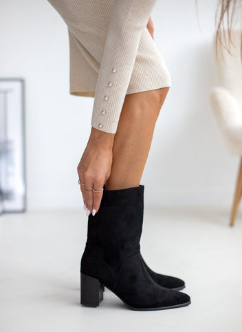Black suede mid calf boots with block heel and pointed toe, side view worn on model
