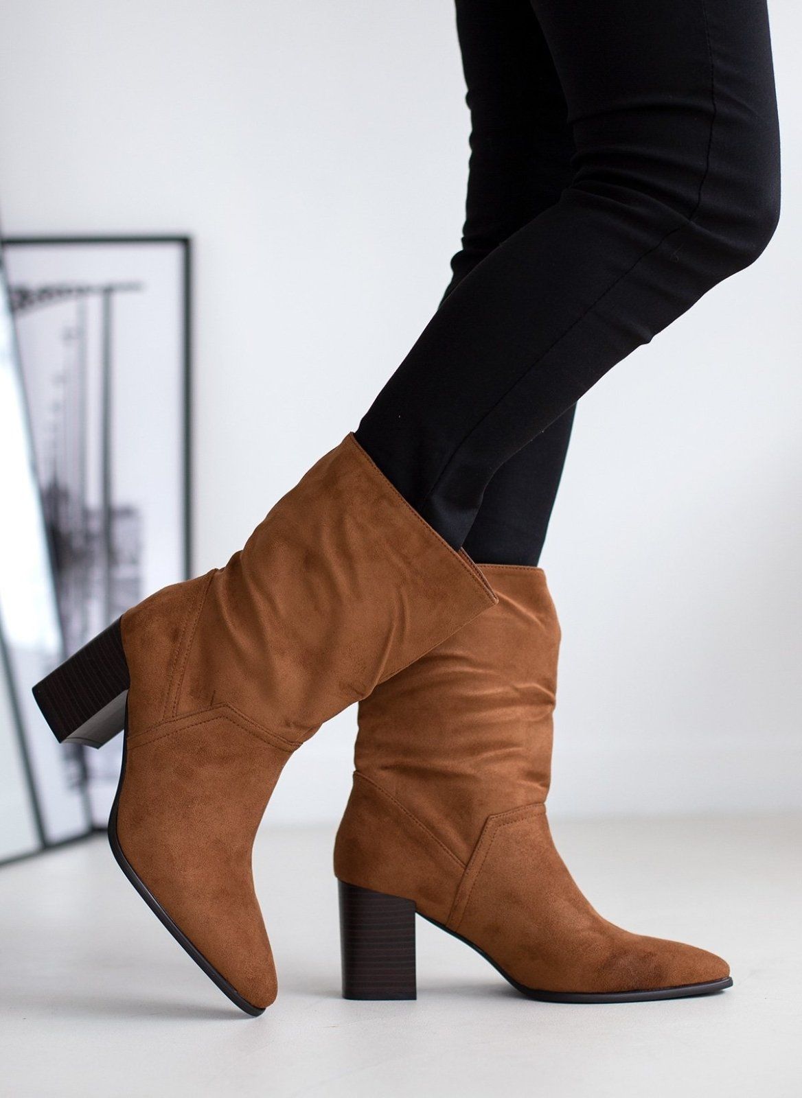 Tan suede pointed toe ankle boots with block heel, walking pose on model, side view
