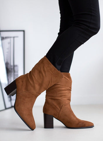 Tan suede pointed toe ankle boots with block heel, walking pose on model, side view