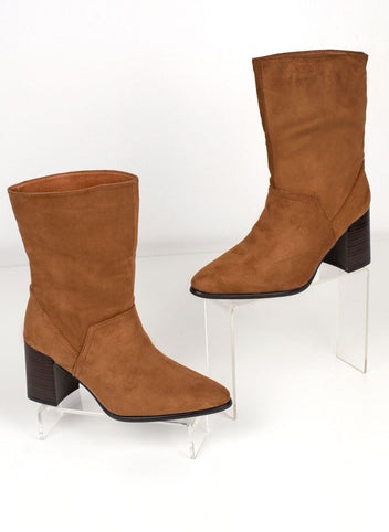 Pair of tan suede ankle boots with dark block heels displayed on clear stands, angled view