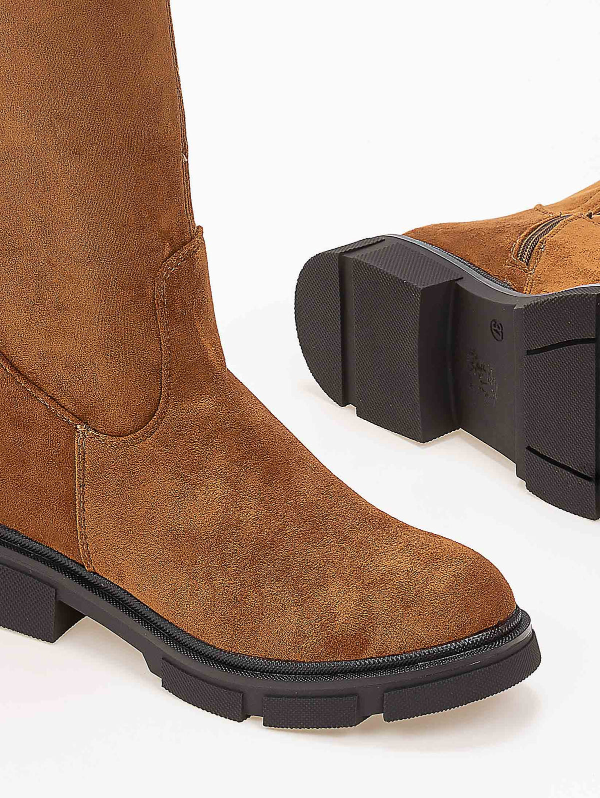 Tan faux suede boot with stitched seam, rounded toe and chunky black lug sole, close-up of toe and sole detail