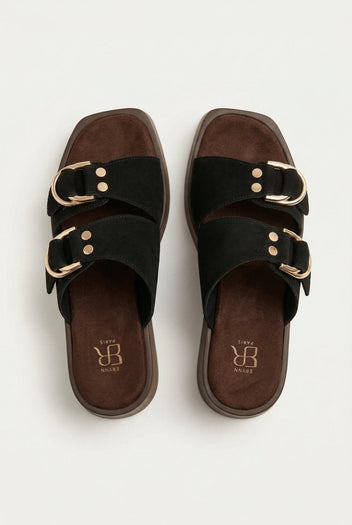 Top view of black suede straps with gold ring buckles and studs over a brown footbed and square toe